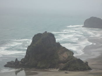 Rock formation in sea against sky