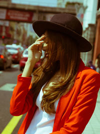 Midsection of woman wearing hat in city