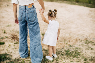 Mom and her little daughter are walking, holding hands, spending time together