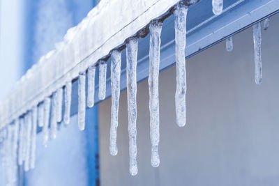 Close-up of icicles hanging against sky