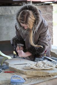 Young woman working on stone