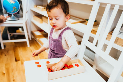 Cute girl standing by table at home