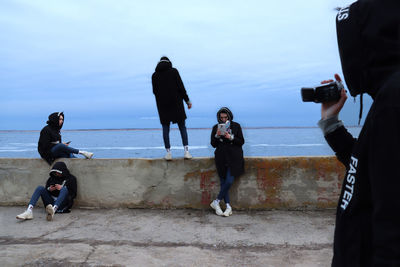 Multiple image of man spending leisure time at beach against sky