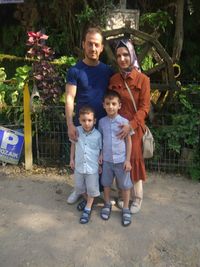 Full length portrait of father and son on footpath