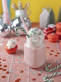 Milkshake and cupcakes on the pink table, retro style, new year vibes 