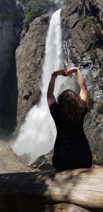 Rear view of woman looking at waterfall