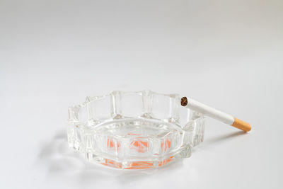 Close-up of cigarette smoking against white background