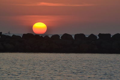 Scenic view of sea against orange sky