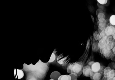 Close-up of woman over black background