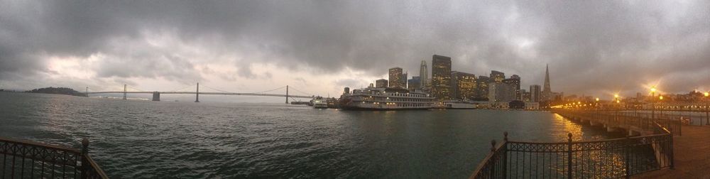 Panoramic view of sea and buildings against sky during sunset