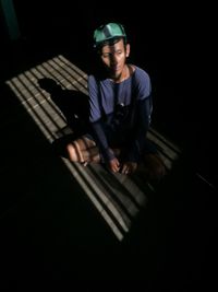 High angle view of man sitting in darkroom