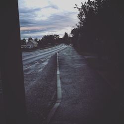 Empty road against cloudy sky