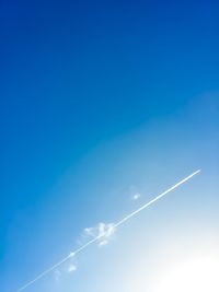 Low angle view of vapor trail in blue sky