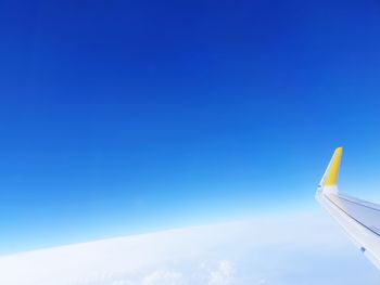 Airplane wing against clear blue sky