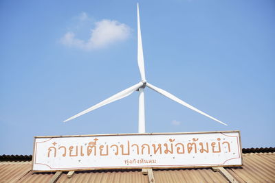 Low angle view of information sign against blue sky