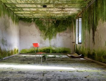 Empty chairs and table in abandoned building