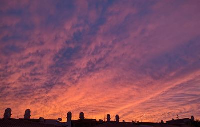 Silhouette buildings against sky during sunset