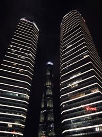 Low angle view of illuminated buildings against sky at night