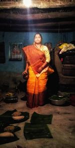 Portrait of smiling woman standing by table