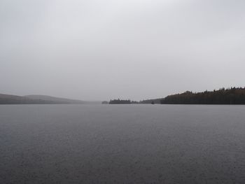 Scenic view of lake against clear sky during winter