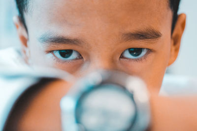 Close-up portrait of boy showing watch
