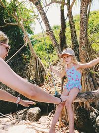 Low angle view of women standing by tree