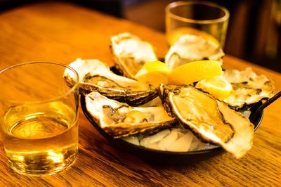 High angle view of oysters with whiskey served on table