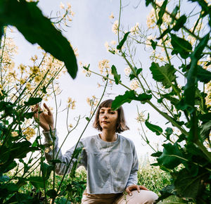 Portrait of woman crouching amidst plants