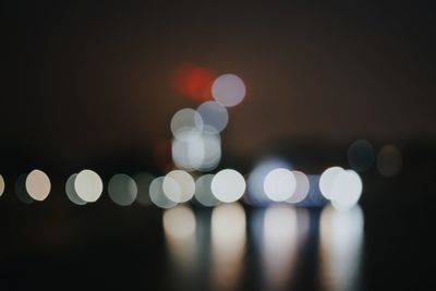 Defocused image of illuminated lights in city at night