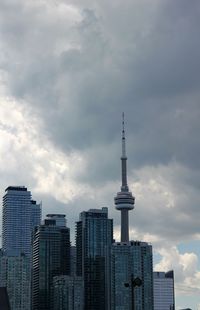 Low angle view of buildings in city against cloudy sky