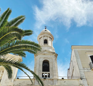 Low angle view of a church and palm tree against sky