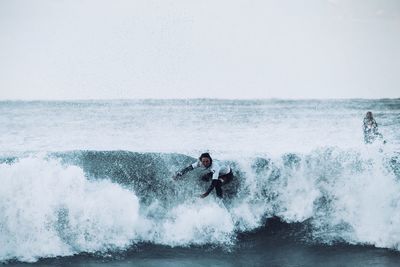 Man surfing on sea against sky