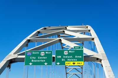 Low angle view of road sign against blue sky