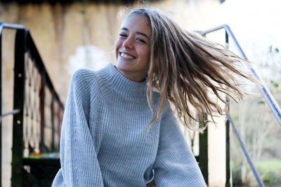 Close-up portrait of smiling teenager sitting on staircase