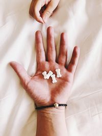 High angle view of human hand on bed