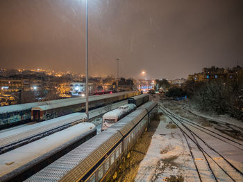 Railroad tracks in city at night during winter