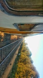 Close-up of railroad tracks by road against sky