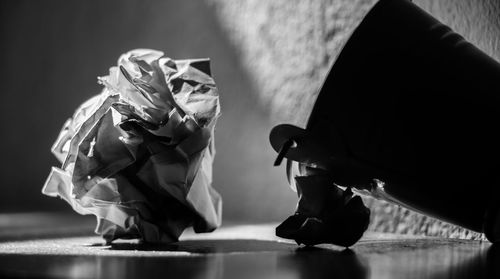 Close-up of crumpled paper by bucket on table