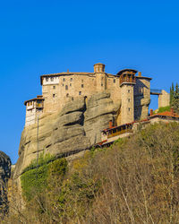 Low angle view of old ruins against clear blue sky