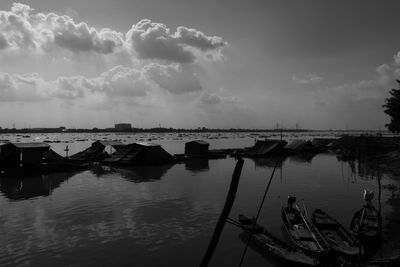 Boats moored at harbor against sky