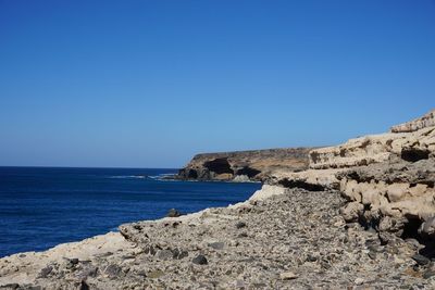 Scenic view of sea against clear blue sky