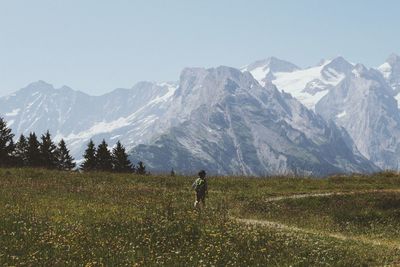 Rear view of person on snowcapped field against sky in switzerland 