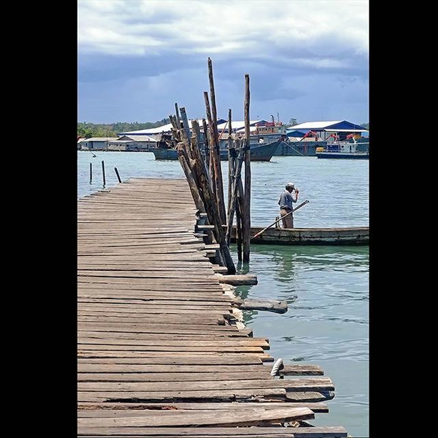 water, pier, sky, sea, nautical vessel, built structure, wood - material, jetty, transportation, cloud - sky, the way forward, railing, boat, architecture, cloud, moored, wood, diminishing perspective, boardwalk, nature