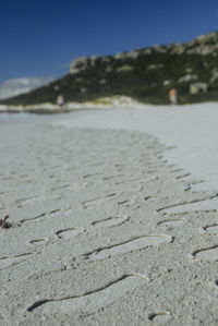 Surface level of sand on beach against sky