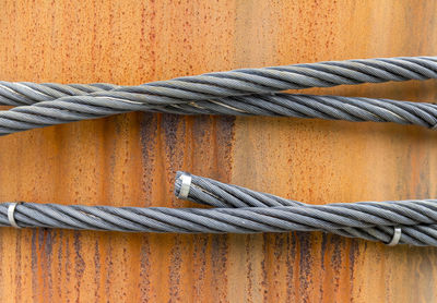 Close-up of rope tied on metal against wall