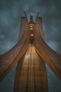 Low angle view of bridge against cloudy sky