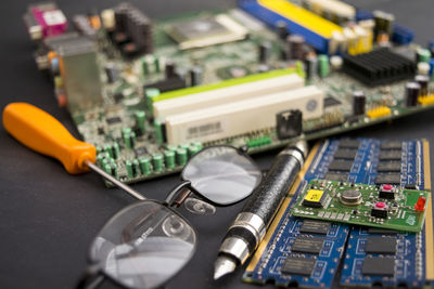 High angle view of circuit board with eyeglasses and pen on table