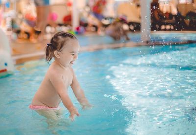 Full length of shirtless boy swimming in pool