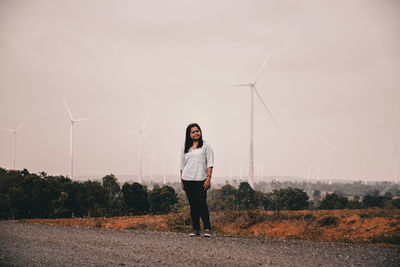 Full length of woman standing on field against sky