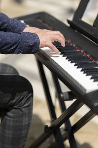 Cropped hand of man playing piano